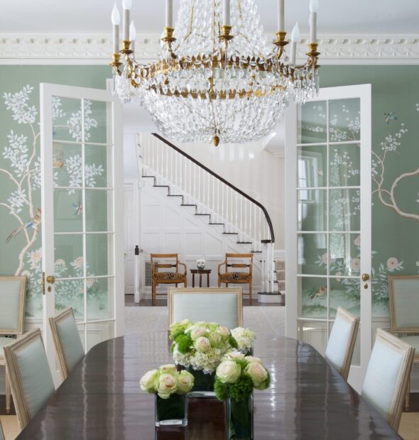 Crystal chandelier hanging above a dining table with floral arrangements in a classic interior   Copy
