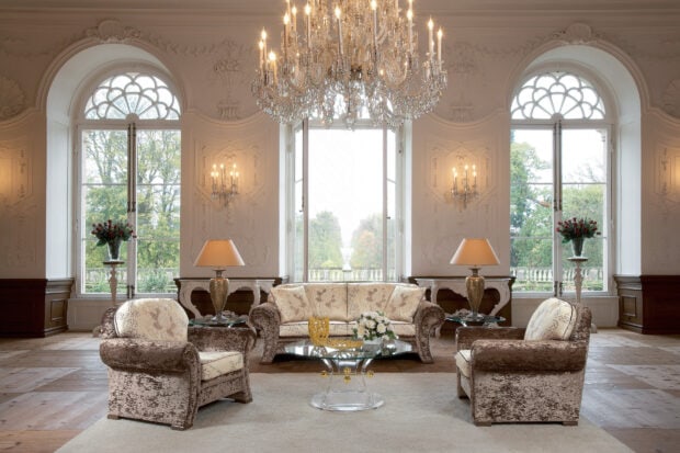 Elegant chandelier in a luxurious living room with classic sofas and large windows   Copy