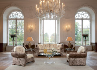 Elegant chandelier in a luxurious living room with classic sofas and large windows