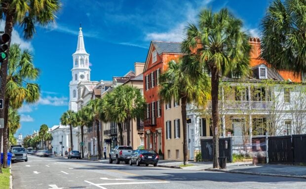 Historic Charleston South Carolina street lined with palm trees and colorful buildings