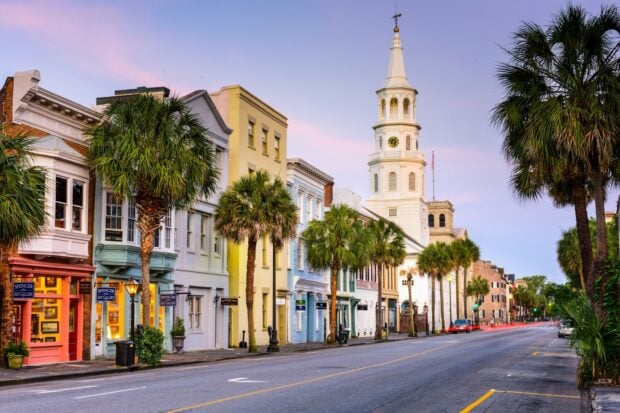 Historic Charleston street with pastel buildings and church steeple in Charleston South Carolina