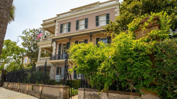 Historic Charleston South Carolina architecture with lush greenery and an American flag