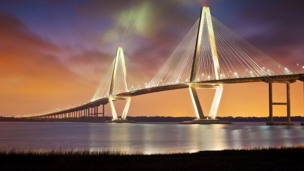 Illuminated suspension bridge in Charleston South Carolina during sunset with vibrant sky