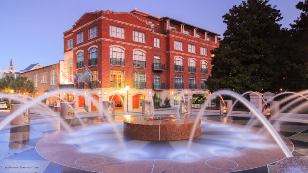 A historic Charleston South Carolina building near a decorative water fountain at dusk