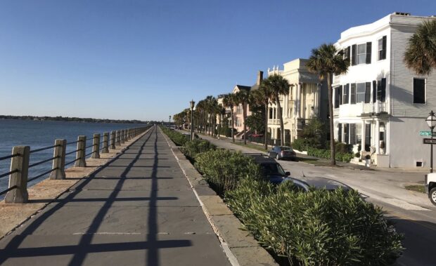Historic architecture and palm trees line the waterfront street in Charleston South Carolina