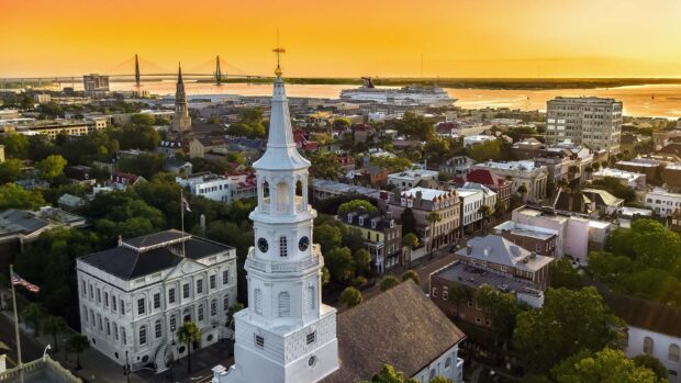 Historic Charleston South Carolina cityscape with church steeple and waterfront at sunset