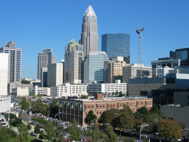 The Charlotte North Carolina city skyline features modern skyscrapers under a clear blue sky, HD Desktop Wallpaper
