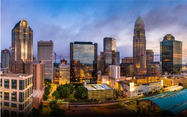 The Charlotte North Carolina skyline features illuminated tall buildings at dusk, 2K Desktop Wallpaper
