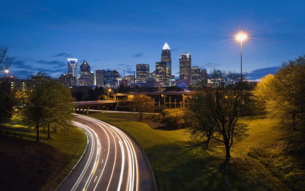 The Charlotte North Carolina skyline is captured with illuminated buildings and light trails from vehicles, HD Desktop Wallpaper
