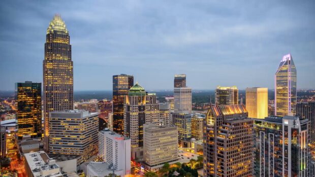 The Charlotte North Carolina skyline shows illuminated buildings and a cloudy sky at dusk, HD Desktop Wallpaper