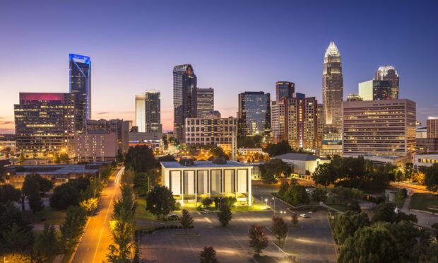 The Charlotte North Carolina skyline shows tall buildings lit up at dusk, HD Desktop Wallpaper