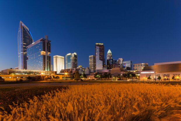 The Charlotte North Carolina Wallpapers city skyline is illuminated under a clear evening sky, HD Desktop Wallpaper