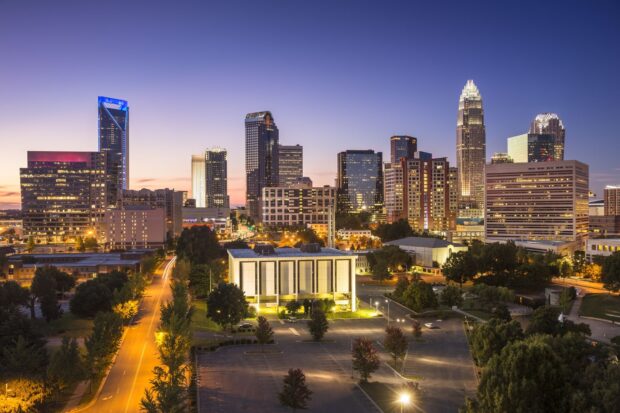 The Charlotte North Carolina skyline glows beautifully at dusk with illuminated buildings and calm streets, HD Desktop Wallpaper