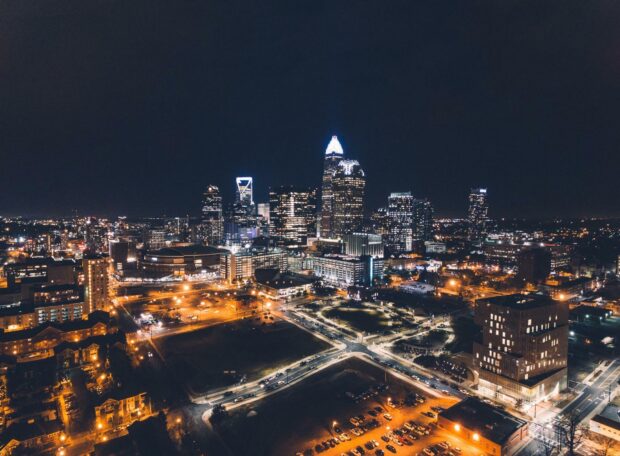 The Charlotte North Carolina skyline glows with city lights against the night sky, HD Desktop Wallpaper
