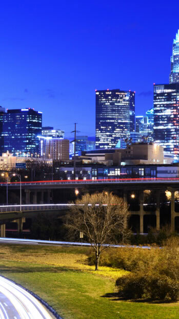 The Charlotte North Carolina skyline is brightly lit with high rise buildings at night, HD Mobile Wallpaper