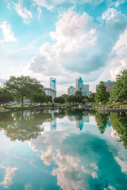 The reflection of Charlotte North Carolina city skyline is shown in the peaceful water pond, HD Mobile Wallpaper