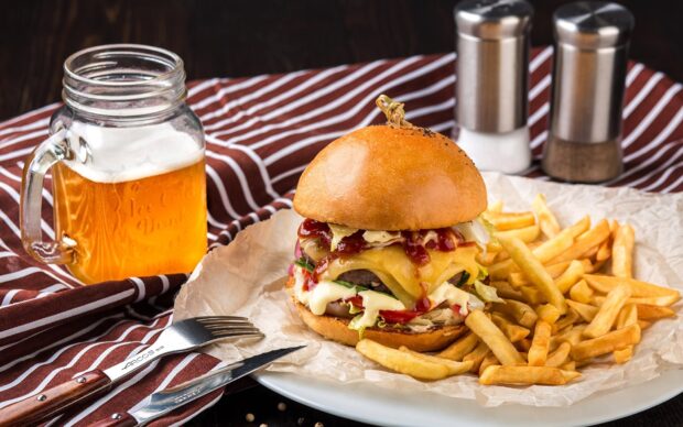 A cheeseburger with melted cheese and sauce is served with crispy French fries and a drink, HD Desktop Wallpaper
