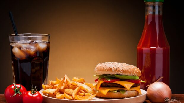 A cheeseburger with melted cheese and ketchup served with crispy French fries and a cold drink, 4K Desktop Wallpaper