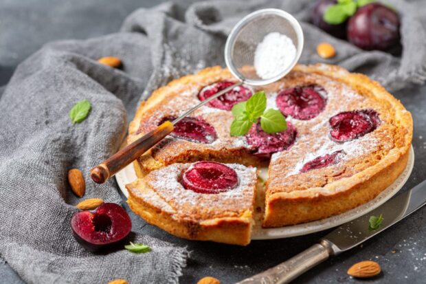 A delicious cherry pie topped with powdered sugar and fresh mint leaves on a plate, HD Desktop Wallpaper