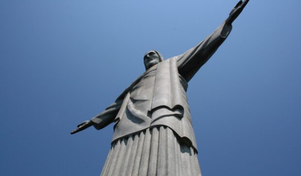 The Christ The Redeemer statue stands tall against a clear blue sky, 2K PC Wallpaper