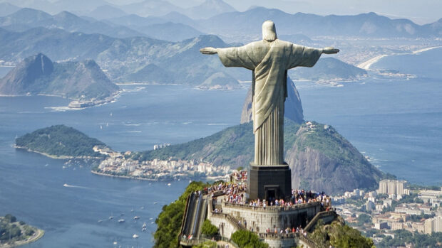 The Christ The Redeemer statue stands tall above Rio de Janeiro with mountains in the background, 2K Desktop Wallpaper