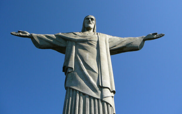 The Christ The Redeemer statue stands tall with outstretched arms against a clear blue sky, HD Desktop Wallpaper