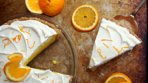 A slice of citrus cream pie with orange garnish and whipped topping, HD Desktop Wallpaper