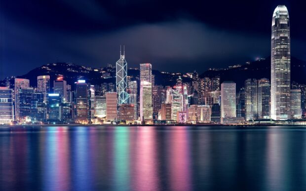 Night cityscape with city skylines reflecting colorful lights on water