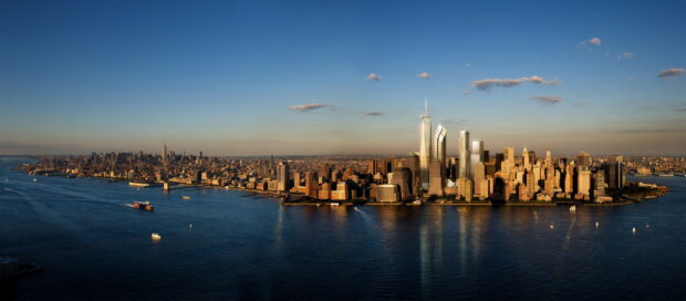 A panoramic view of a city skyline with skyscrapers and waterfront during sunset featuring city skylines