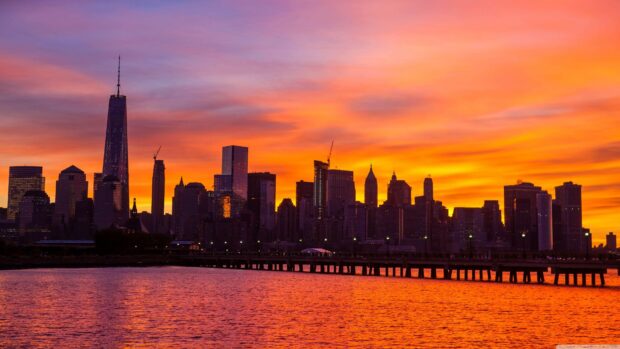 Vibrant city skylines at sunset with glowing orange sky reflecting on the water
