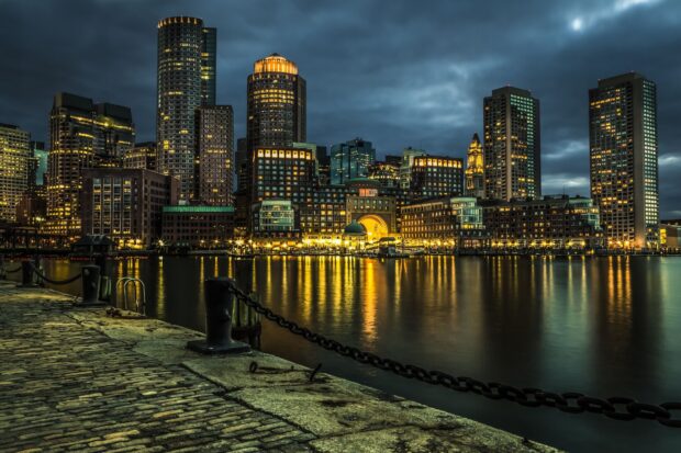 Night city skyline with illuminated buildings reflecting on the water in a metropolitan area