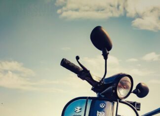 Vintage Bajaj scooter on roadside during sunset.