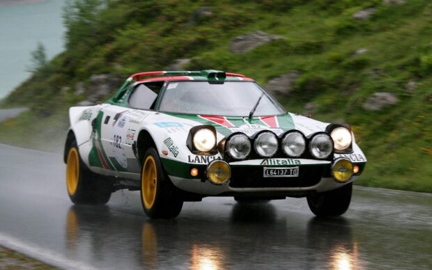 A classic Lancia rally car is driving fast on a rainy curvy road, HD Desktop Wallpaper