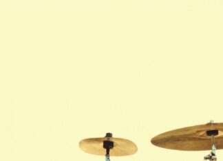 Drum set in wheat field during golden hour.
