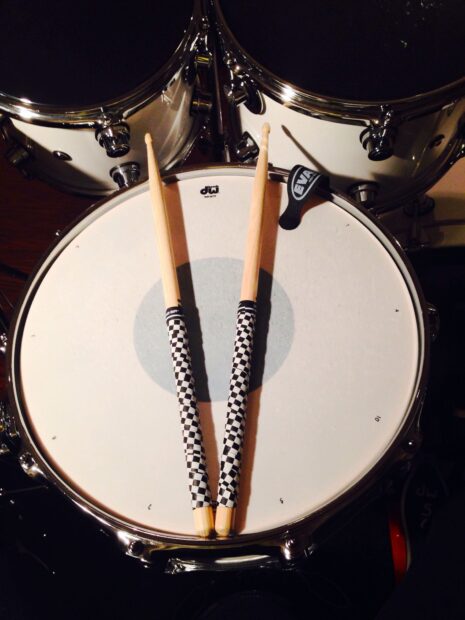 A close up view of drums with checkered drumsticks placed on the snare head, HD Mobile Wallpaper