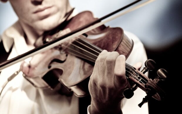 A close up of a man playing the violin with skilled fingers, 2K Desktop Wallpaper