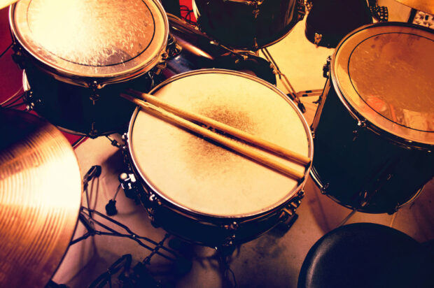 A drum set with sticks resting on the snare drum is ready to be played, HD Desktop Wallpaper