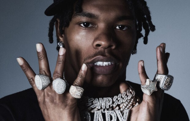 Lil Baby wearing multiple diamond rings and chains in a close up portrait, 2K Desktop Wallpaper