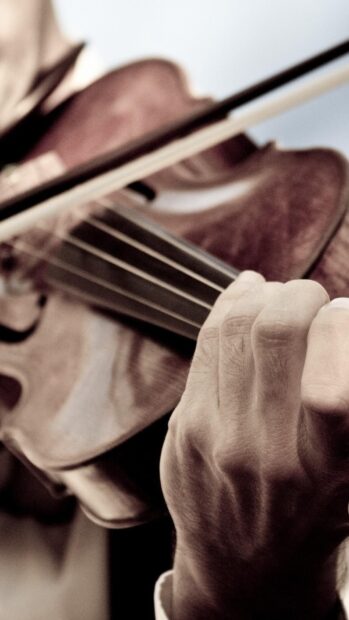 A hand holds a violin bow while playing an acoustic violin, HD Phone Wallpaper