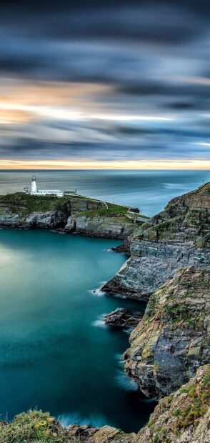 A stunning view of coastal cliffs and a lighthouse under a cloudy sky in Bulgaria Wallpapers, 2K Mobile Wallpaper
