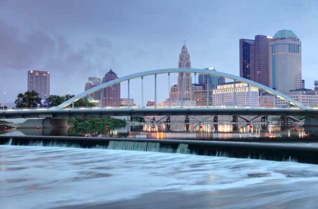 The scenic Columbus Ohio skyline with the Arch bridge over the river at dusk