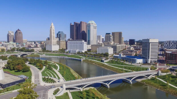 A scenic view of Columbus downtown skyline with river and bridge in Ohio