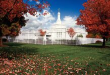 The Columbus Ohio temple surrounded by autumn trees and green grass