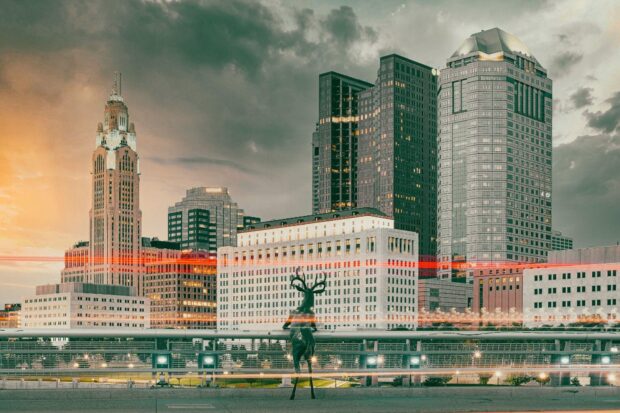 The Columbus skyline at sunset with a deer statue in the foreground of Ohio