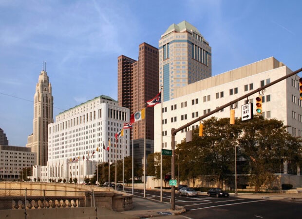 Columbus Ohio downtown skyline with tall buildings and state flags on a clear day