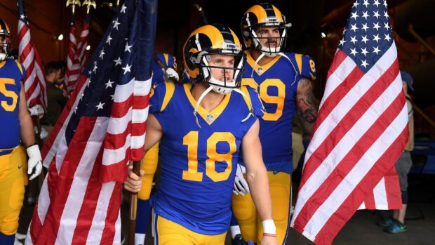 Cooper Kupp preparing for the game while holding an American flag in football uniform