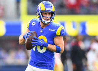 Cooper Kupp preparing to throw a football during an NFL game in Rams uniform