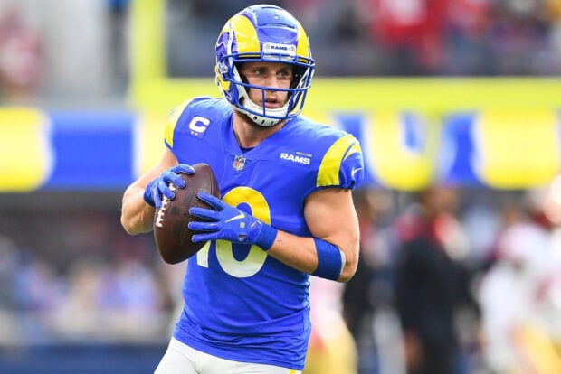 Cooper Kupp preparing to throw a football during an NFL game in Rams uniform