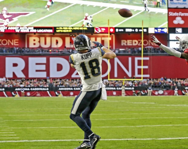Cooper Kupp catching a football on the field during a game in the stadium