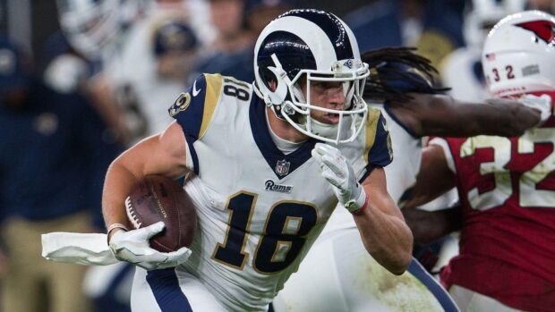 Cooper Kupp running with a football during a game wearing a Rams uniform